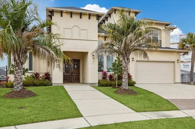 a front view of a house with a garden and plants