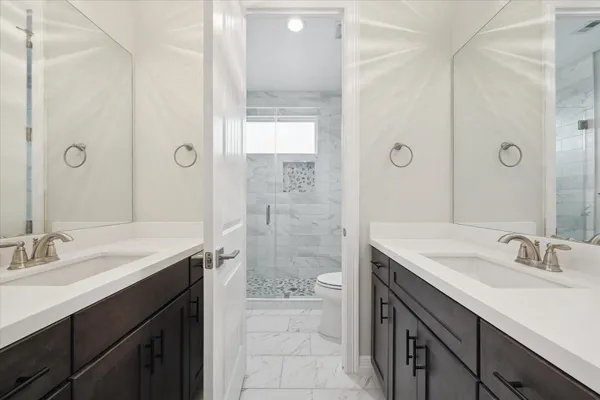 a bathroom with a sink toilet a mirror and shower