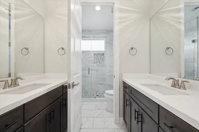 a bathroom with a sink toilet a mirror and shower