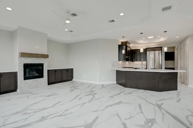 a view of kitchen with kitchen island stainless steel appliances a sink counter top space and living room
