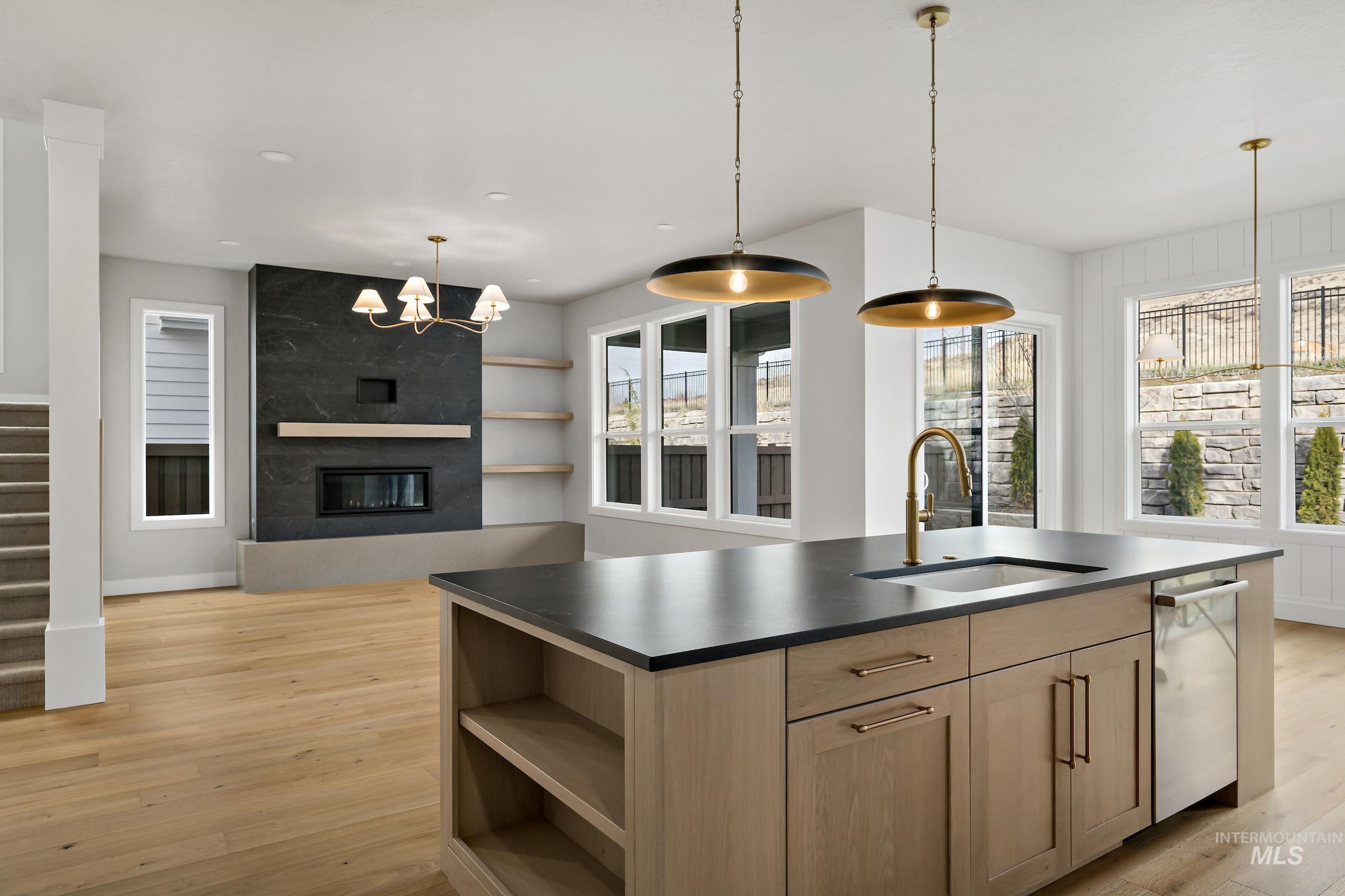 11708 North Rabbitbrush Way Boise, ID 83714 - Photo 13 of 33 Kitchen featuring an island with sink, open shelves, a chandelier, light wood finished floors, and dark countertops