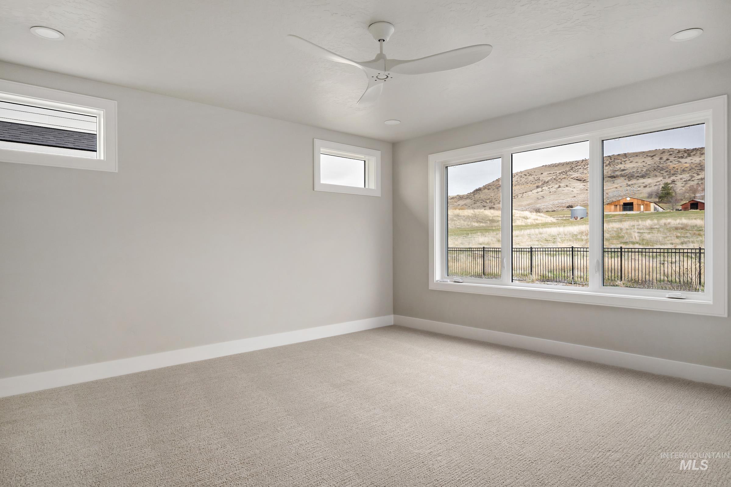11708 North Rabbitbrush Way Boise, ID 83714 - Photo 16 of 33 Carpeted spare room with healthy amount of natural light, ceiling fan, and recessed lighting