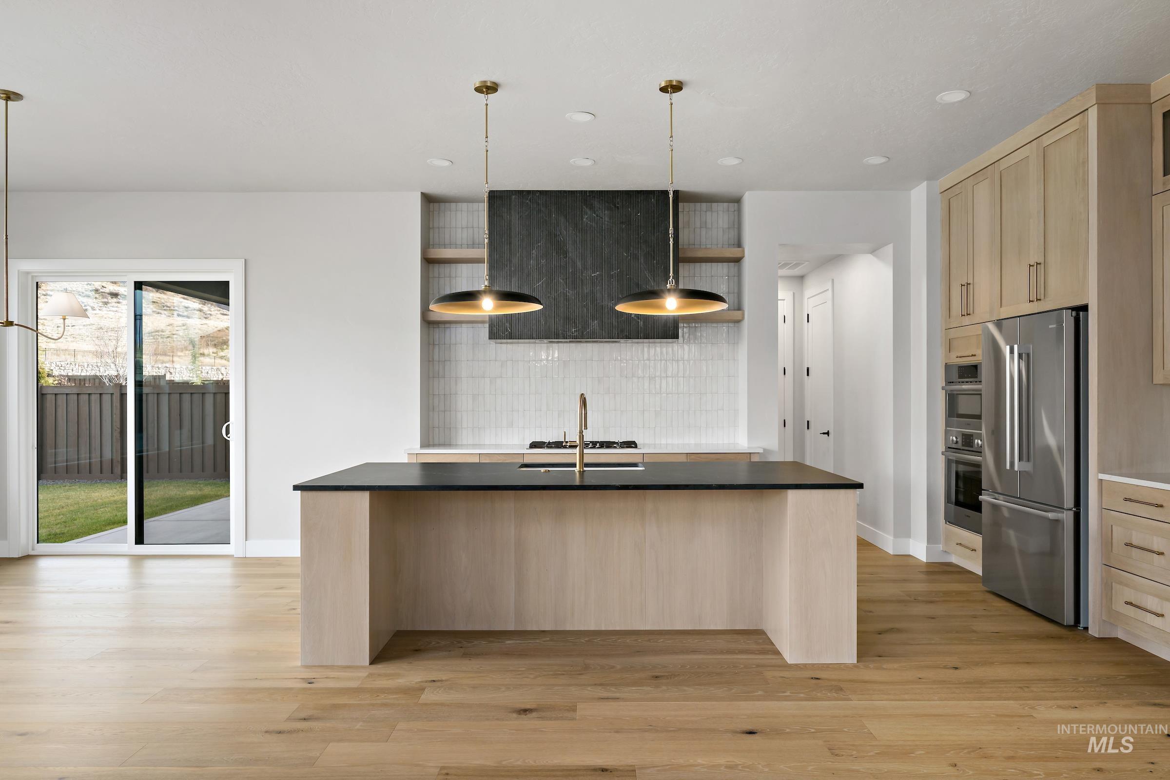 11708 North Rabbitbrush Way Boise, ID 83714 - Photo 3 of 33 Kitchen featuring light brown cabinets, an island with sink, decorative backsplash, appliances with stainless steel finishes, and recessed lighting