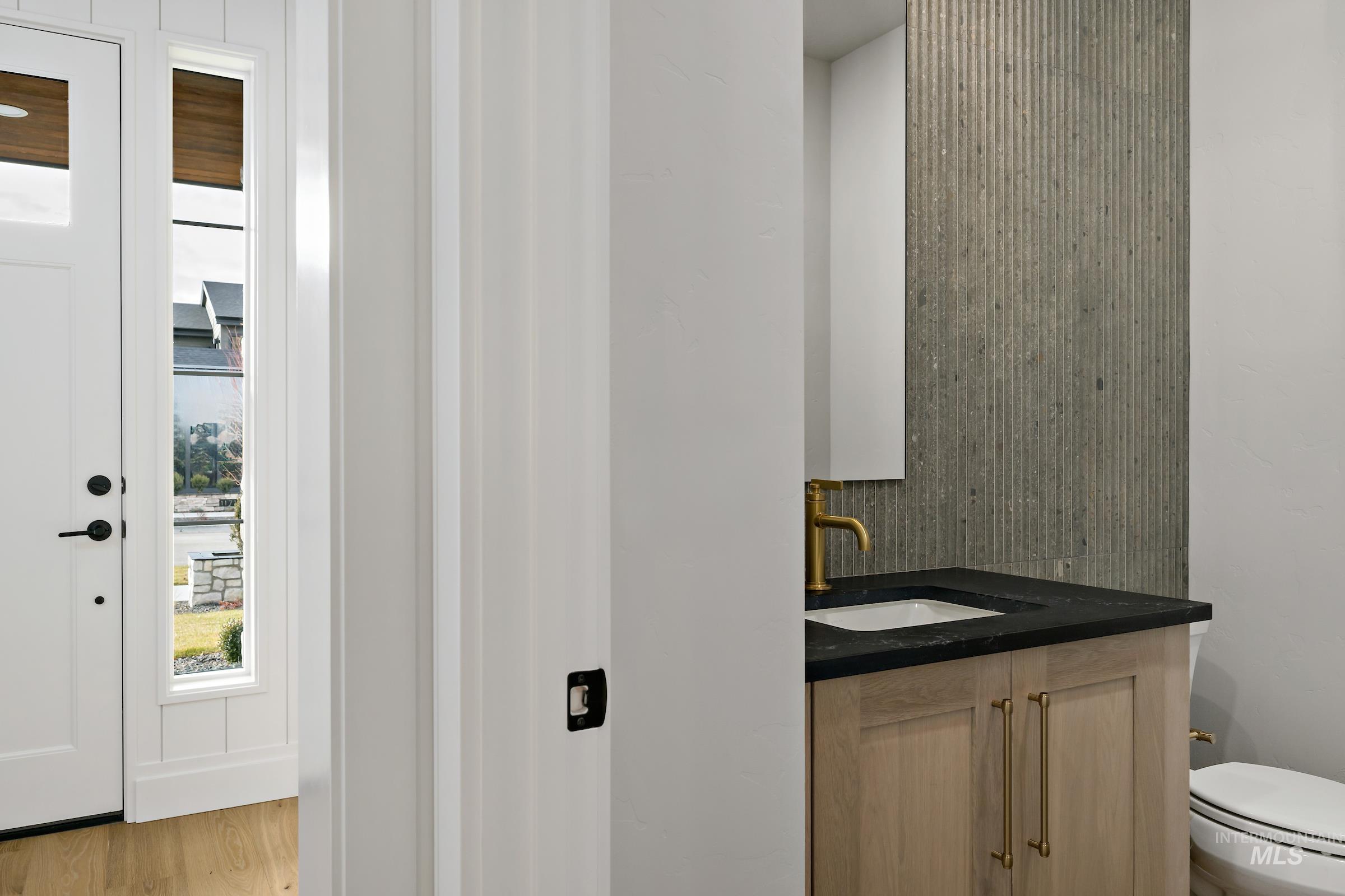 11708 North Rabbitbrush Way Boise, ID 83714 - Photo 4 of 33 Half bath featuring vanity, tasteful backsplash, and light wood-type flooring