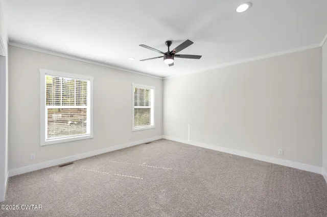 an empty room with windows and fan