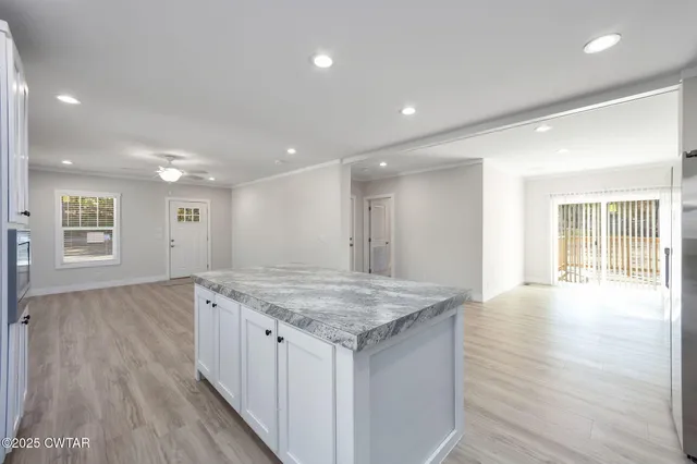 a view of kitchen island a sink and wooden floor