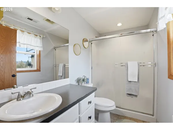 a bathroom with a granite countertop sink toilet and shower