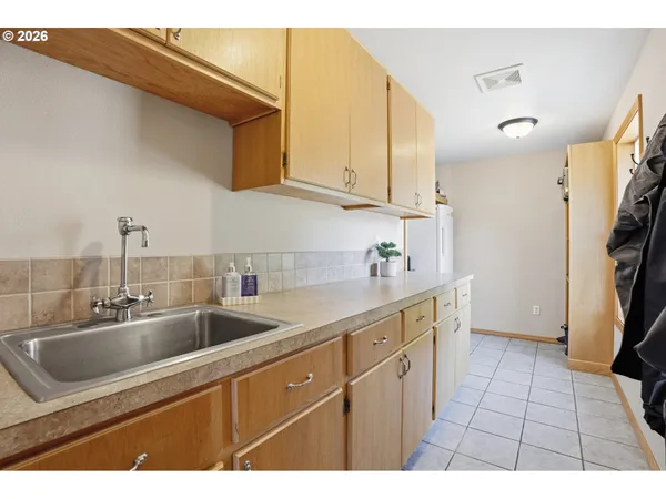 a kitchen with a sink a refrigerator and cabinets