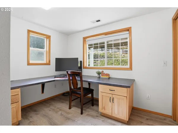 a view of a workspace with furniture and a window