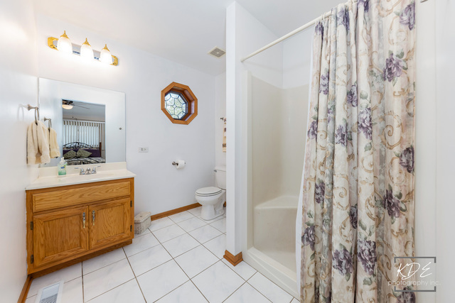 701 Bishops Gate New Lenox, IL 60451 - Photo 20 of 27 a spacious bathroom with a granite countertop sink a mirror and a shower
