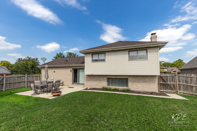 701 Bishops Gate New Lenox, IL 60451 - Photo 24 of 27 a view of a backyard with table and chairs potted plants and a large tree