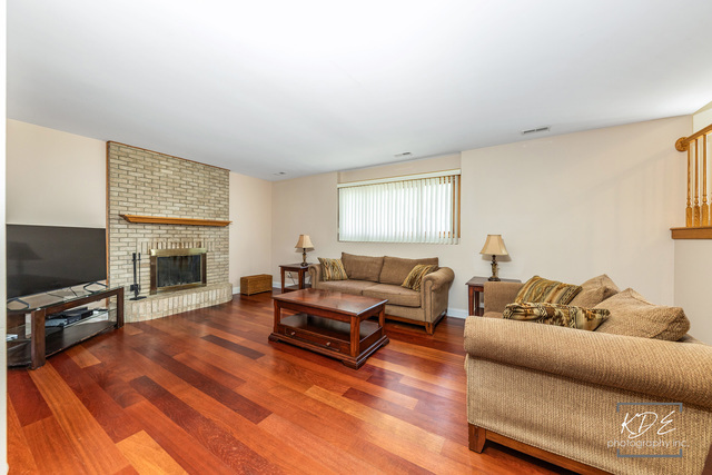 701 Bishops Gate New Lenox, IL 60451 - Photo 7 of 27 a living room with furniture a flat screen tv and a fireplace