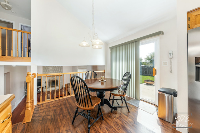 701 Bishops Gate New Lenox, IL 60451 - Photo 8 of 27 a dining room with furniture a chandelier and wooden floor