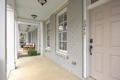 a kitchen with stainless steel appliances granite countertop a stove a sink a microwave a refrigerator and white cabinets with wooden floor