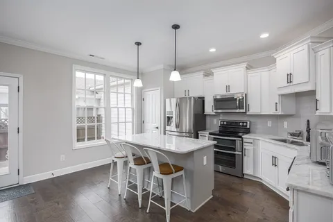 a view of a hallway with wooden floor and staircase