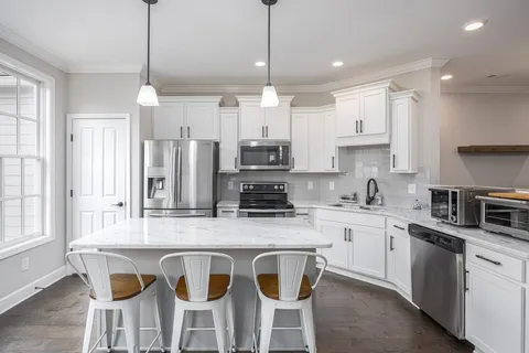 a bathroom with a granite countertop sink two mirror and a