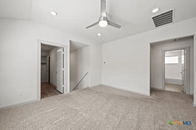 an empty room with a bathroom and a mirror