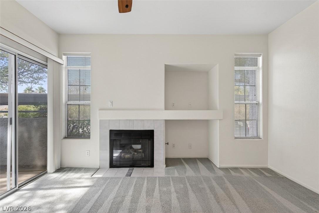 2201 Ramsgate Drive, Unit 1011 Henderson, NV 89074 - Photo 6 of 40 A cozy living space features a fireplace with a white tile surround, perfect for relaxation.