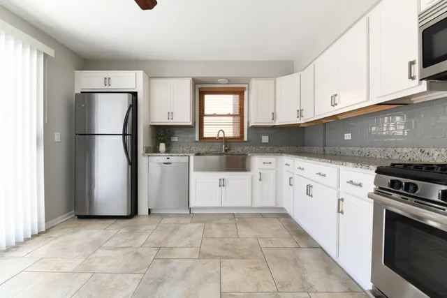 a kitchen with a refrigerator sink and cabinets