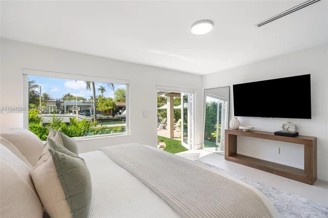 a living room with couch a flat screen tv and a floor to ceiling window