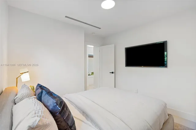 a bedroom with a bed and a flat screen tv