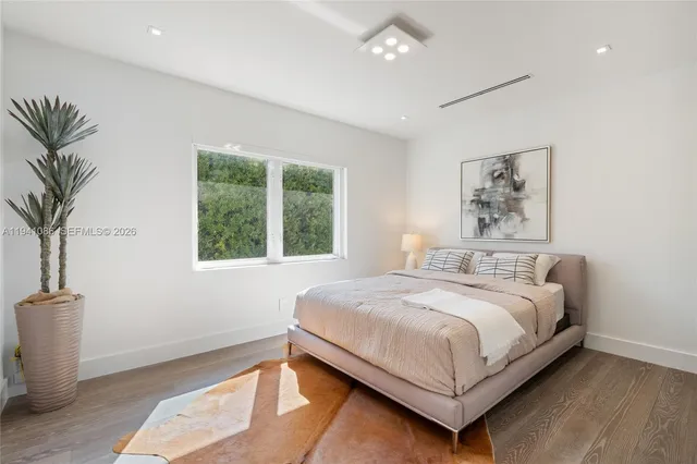 a bedroom with a large bed and a potted plant