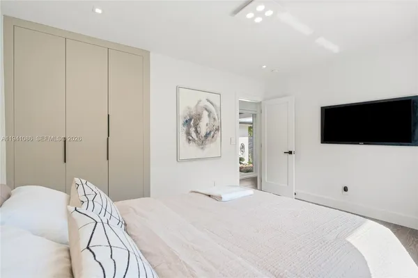 a bedroom with a bed and a flat screen tv