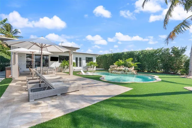 a front view of a house with swimming pool having outdoor seating