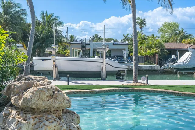 a view of a swimming pool with a lawn chairs and palm trees