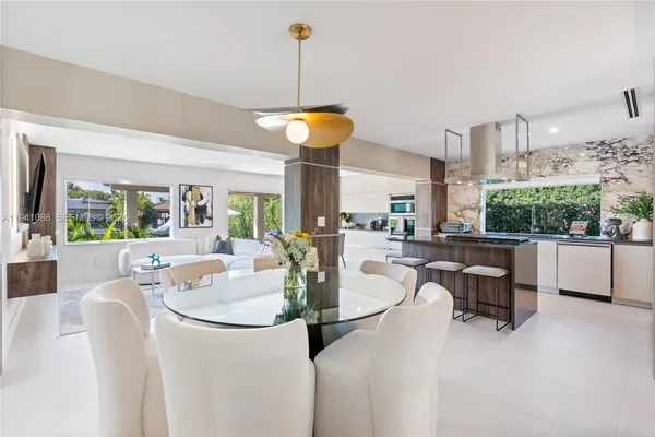 a dining room with furniture a chandelier and wooden floor