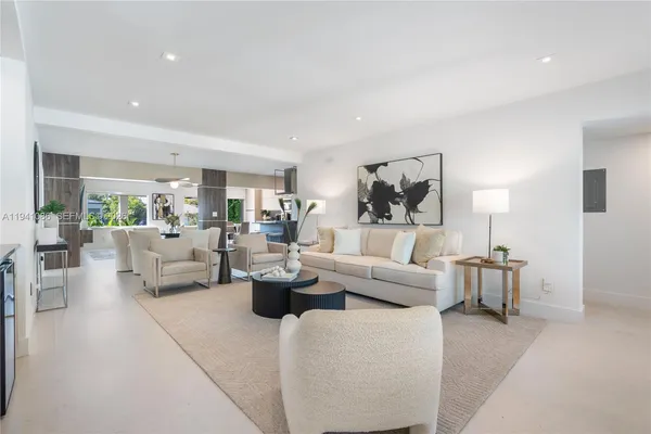 a living room with fireplace furniture and a large window