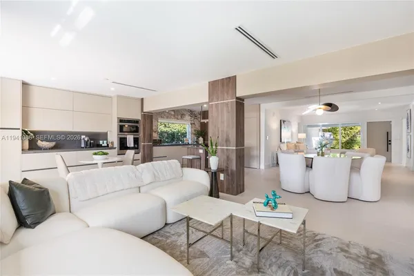 a living room with furniture and a view of kitchen