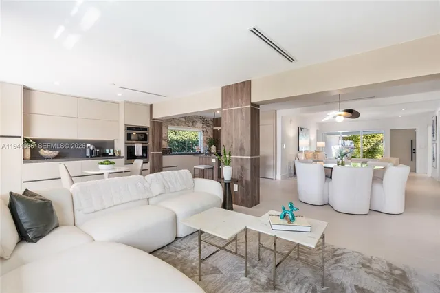 a living room with furniture and a view of kitchen