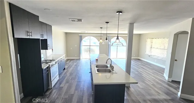 a kitchen with sink refrigerator and wooden floor