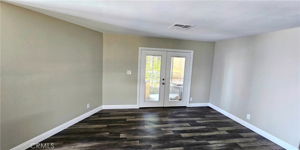 9800 Base Line Road, Unit 82 Alta Loma, CA 91701 - Photo 19 of 28 a view of an empty room with wooden floor and a window