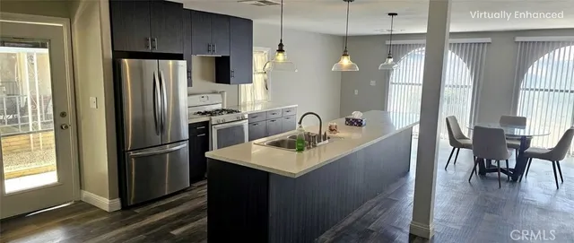 a kitchen with refrigerator a sink and chairs
