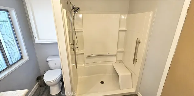 a bathroom with a granite countertop toilet and a shower