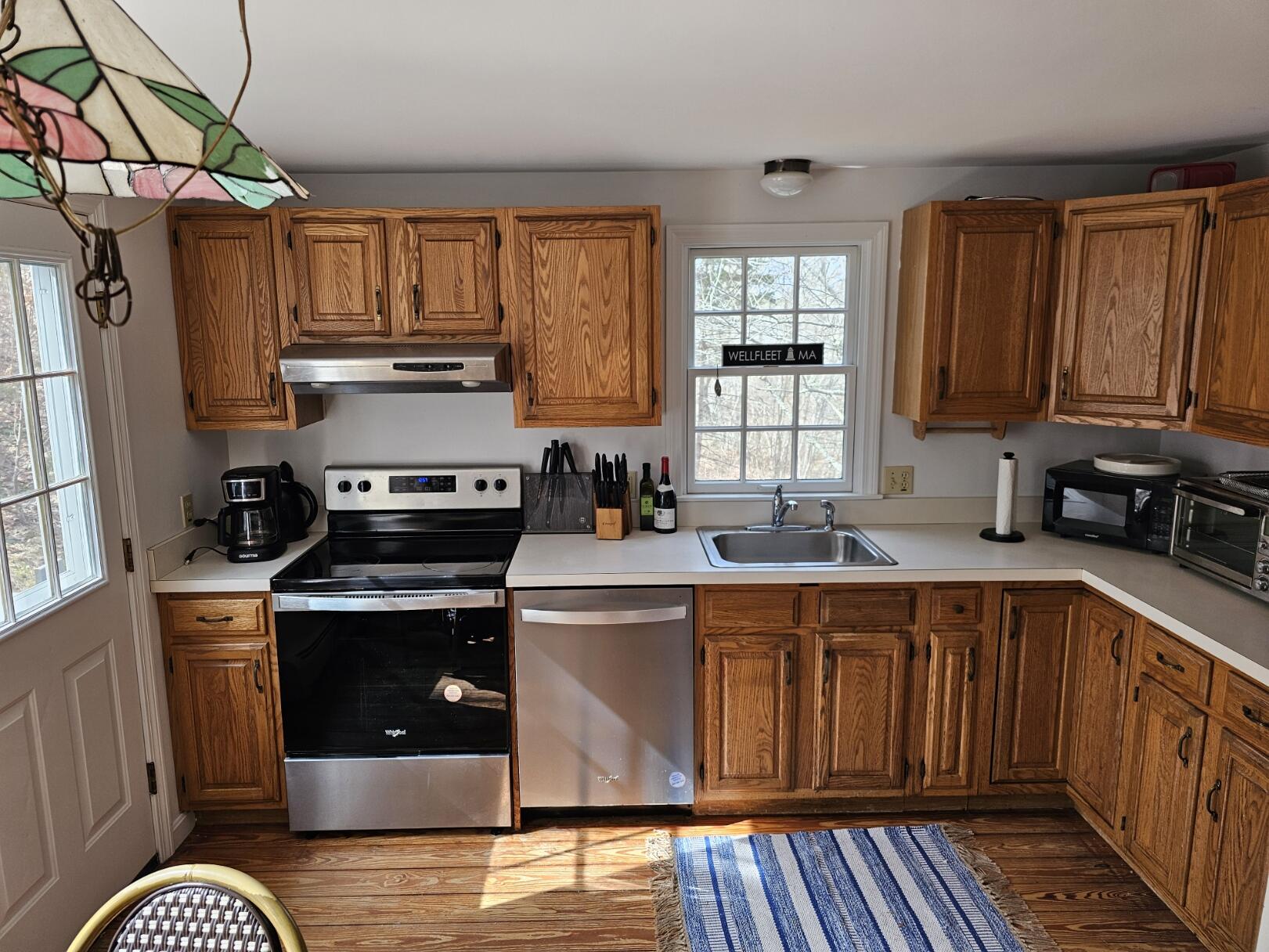 3098 State Highway Wellfleet, MA 02667 - Photo 9 of 13 a kitchen with a stove sink and cabinets