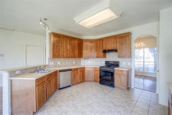 a kitchen that has a lot of cabinets in it and wooden floors