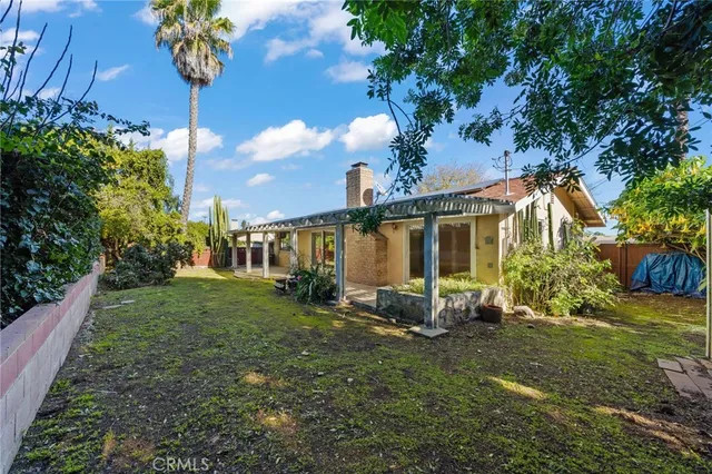 a view of a house with backyard and sitting area