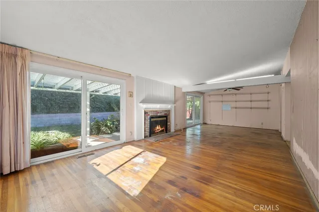 a view of empty room with wooden floor and fireplace