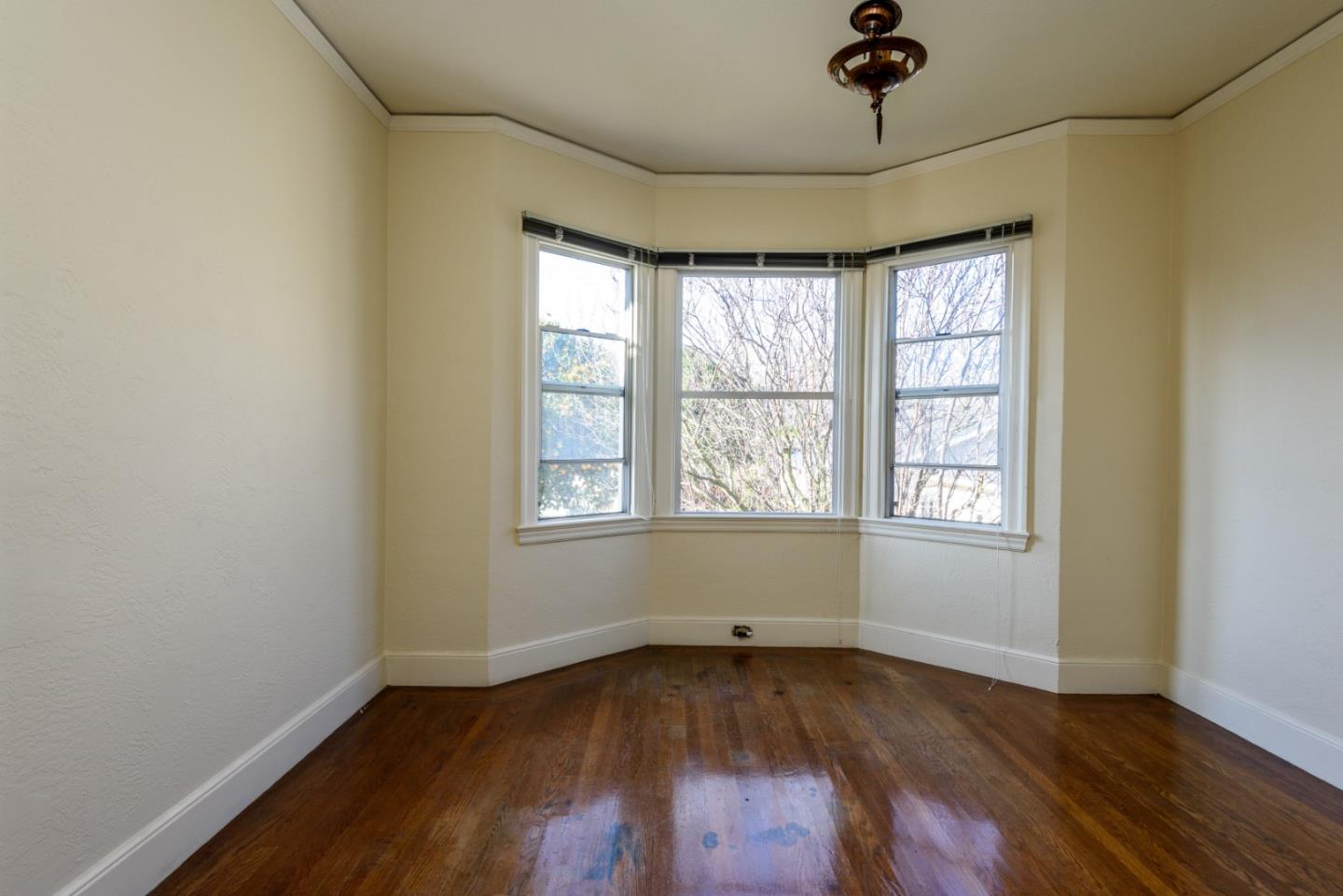 34 Dwight Road Burlingame, CA 94010 - Photo 9 of 13 an empty room with wooden floor and windows