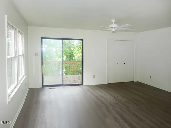 a view of a livingroom with wooden floor and a window