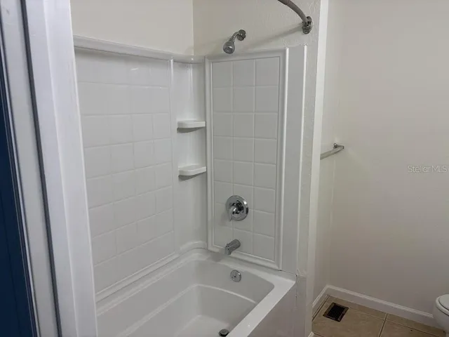 a bathroom with a granite countertop toilet and a sink
