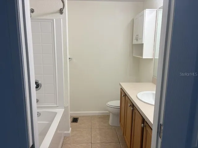 a bathroom with a granite countertop toilet and a sink