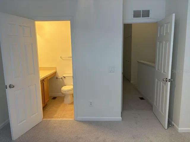 a view of an empty room with closet and a window