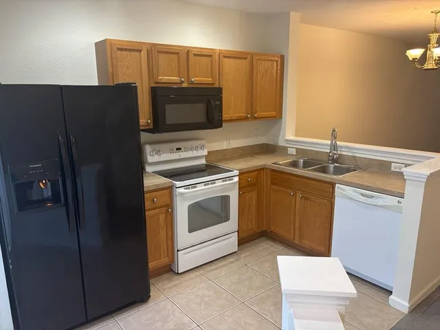 an empty room with wooden floor and chandelier