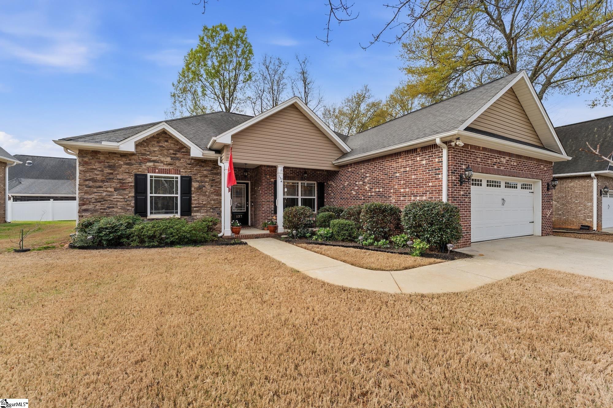 Lovely covered front porch on this all brick home with stacked stone accents.