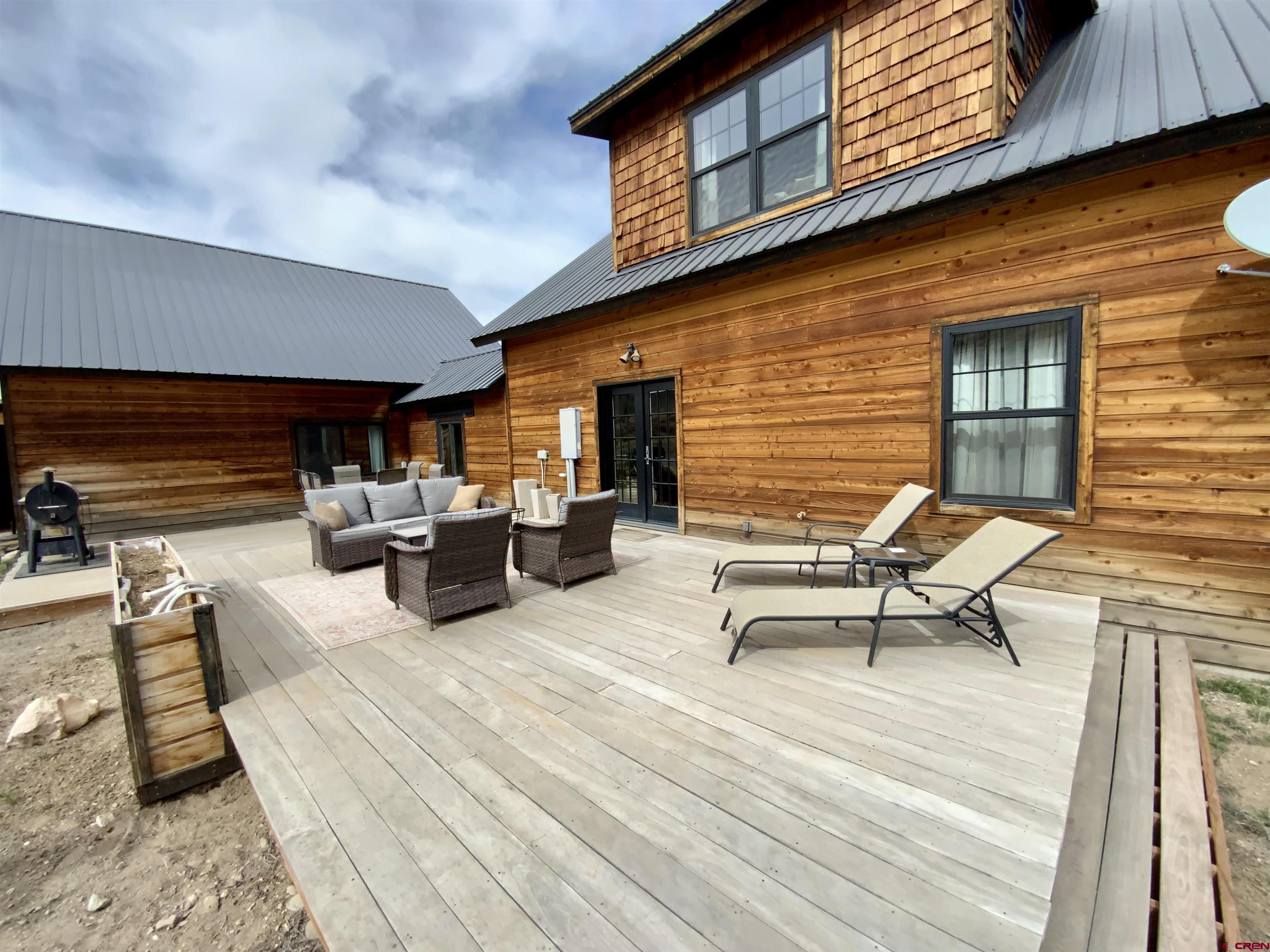 31876 State Highway Gunnison, CO 81230 - Photo 25 of 28 a view of a patio with dining table and chairs with wooden floor and fence