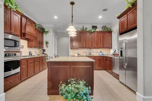 a large kitchen with stainless steel appliances granite countertop a refrigerator a stove and a sink
